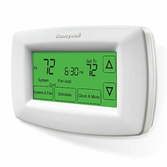 Digital thermostat with green screen displaying temperature settings.