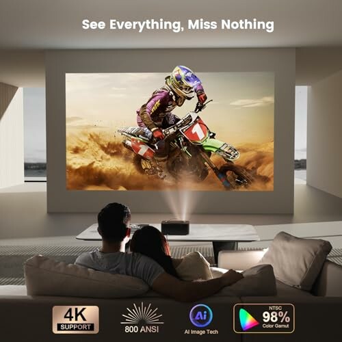 Couple watching motorcycle race on home theater projector.