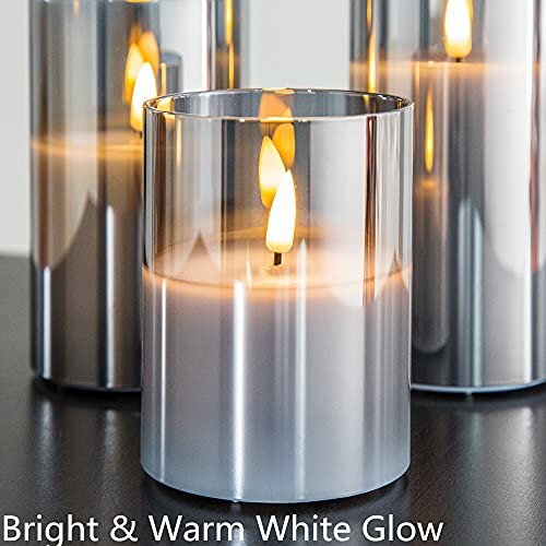 Silver cylindrical candles with bright warm white glow