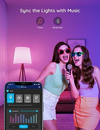 Two women singing with synced smart lights in a room.